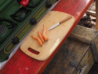 a wooden cutting board with carrots on it